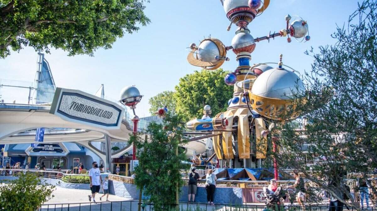 ANAHEIM, CA - APRIL 30: In this handout photo provided by Disneyland Resort, Guests watch the rides in Tomorrowland at the Disneyland Resort on April 30, 2021 in Anaheim, California. Guests are being welcomed back as Disneyland Park, Disney California Adventure Park and Disney's Grand Californian Hotel & Spa are reopening. (Photo by Christian Thompson/Disneyland Resort via Getty Images)