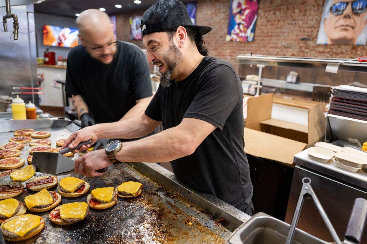 Roberto Castro, owner of The Philly restaurant on K Street, prepares hamburgers to help feed the homeless downtown on Tuesday. “It really hurt me as a Sacramento native for people to hit me back like that,” Castro said about the criticism he received for supporting the governor’s return to office order.