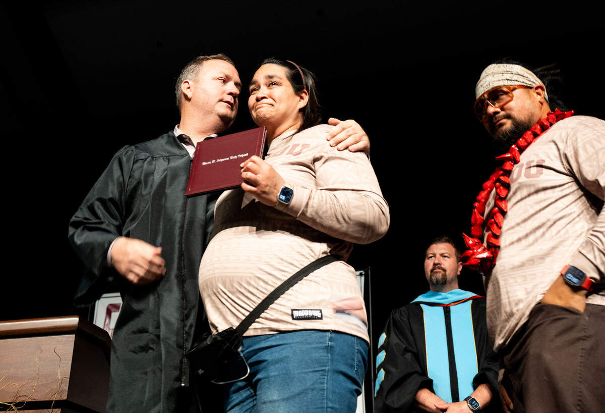 Kaila Fitiausi, center, and Sole Fitiausi, right, receive an honorary diploma for their daughter, Taupau Fitiausi, who passed away in 2024, at the Hiram Johnson High School graduation on Wednesday.