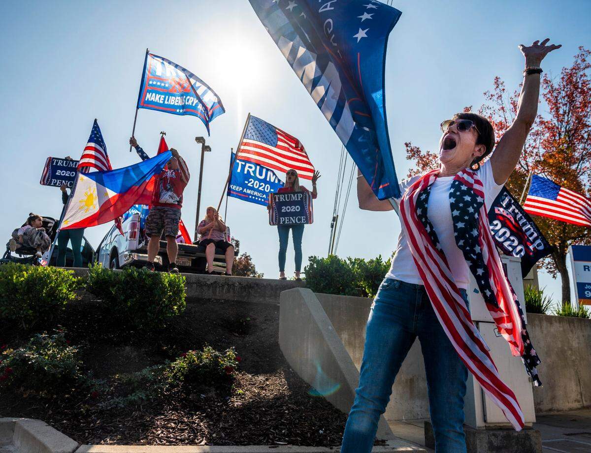 Trump supporters gather and wave flags at the intersection of Cirby Way and Sunrise Avenue in Roseville on Election Day on Tuesday, Nov. 3, 2020.