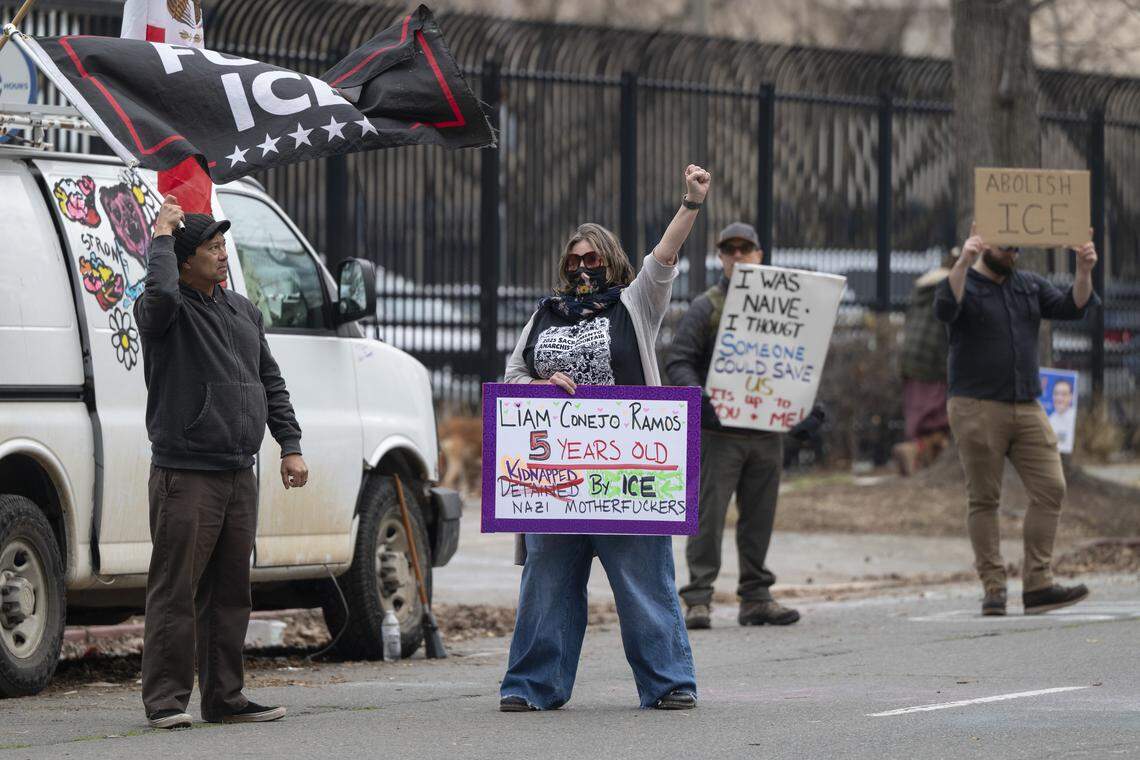 Anti-ICE protesters wave signs outside the John Moss Federal Building in Sacramento on Sunday. Protesters have been protesting outside the building on and off for months since Immigration and Customs Enforcement started detaining immigrants in the building.