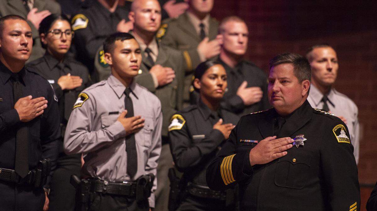 Sheriff Scott Jones stands for the Pledge of Allegiance during a Sheriff’s Academy graduation in June in Sacramento.