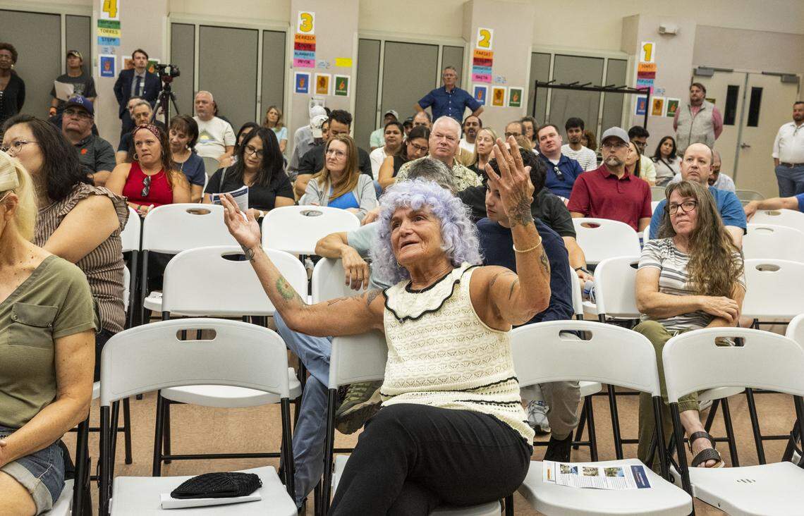 Natomas resident Rosalee Lehr raises her hands in objection as Brian Pedro, director of Sacramento's Department of Community Response, speaks during a community meeting  at Witter Ranch Elementary School about a proposed homeless micro-community in the neighborhood on Monday.
