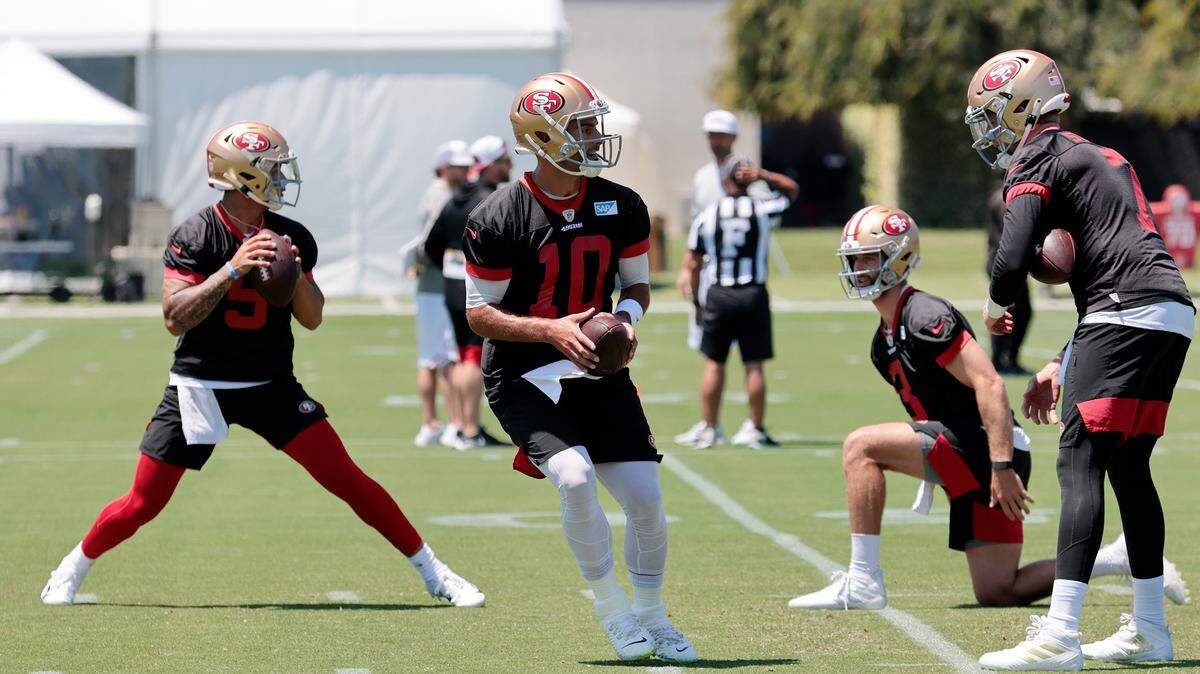 San Francisco 49ers quarterbacks Trey Lance, left, and Jimmy Garoppolo look to pass during workouts Wednesday.