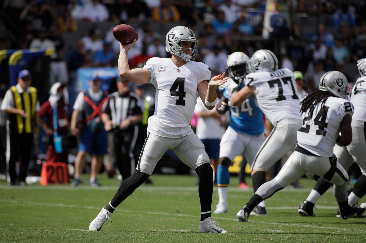 Raiders quarterback Derek Carr throws a pass in a 26-10 loss to the Los Angeles Chargers while left tackle Kolton Miller (77) blocks Sunday, Oct. 7, 2018 in Carson. Carr, the former Fresno State star, hit 24 of 33 passes for 268 yards with one touchdown and one interception.