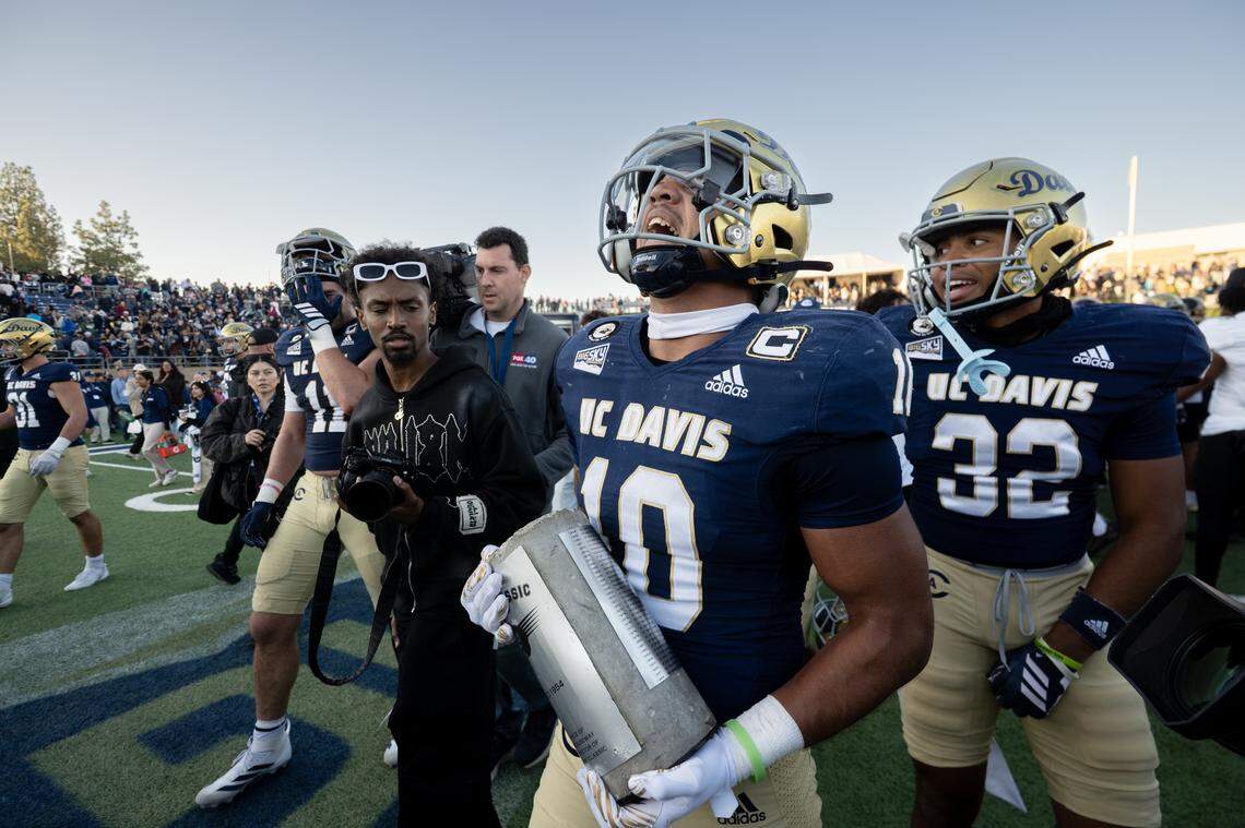 UC Davis Aggies defensive back Jayden Stanley (10) carries the Causeway Carriage trophy following the 31-27 victory over the Sacramento State Hornets in the Causeway Classic on Saturday, Nov. 22, 2025 in Davis.