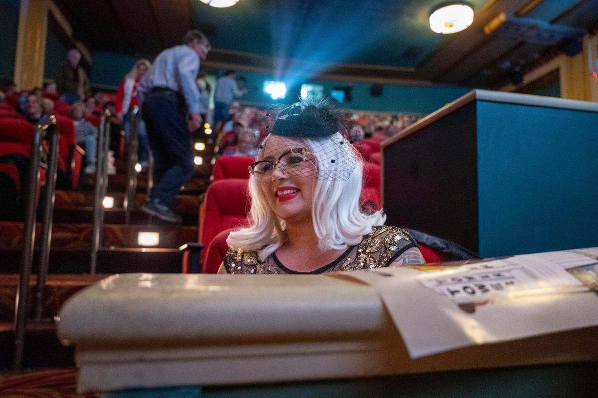 Sacramento resident Kendall Tobe, dressed in a vintage outfit, sits in the auditorium of the Tower Theatre to watch a screening of the 1988 drama “Cinema Paradiso” on Saturday, Dec. 2, 2023, during a celebration of the theater’s 85th anniversary.