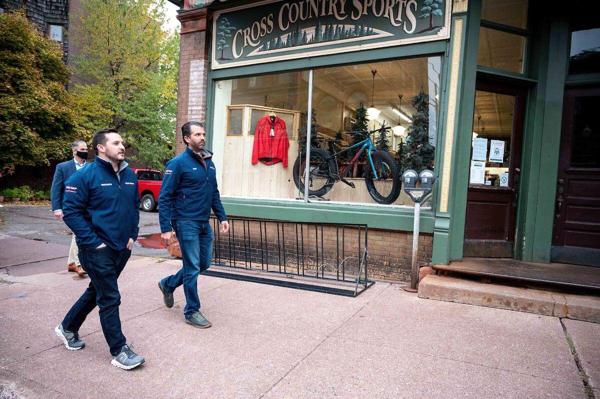 Taylor Budowich, left, walks down the street in Calumet, Mich., with Donald Trump Jr. during a campaign swing in October 2020. The week included visits to North Carolina, Virginia, Pennsylvania, Illinois, Michigan, Ohio, Pennsylvania and Georgia, according to Budowich’s Instagram account.