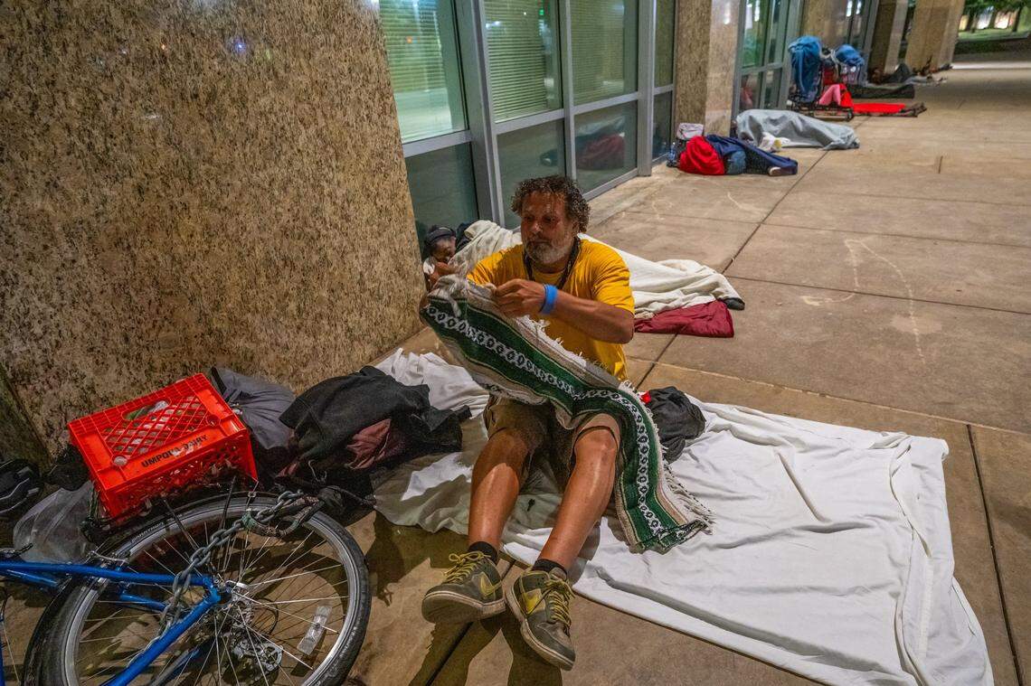 James D’Errico, 50, pulls out a blanket to go to sleep after chaining his bike to his belongings at Sacramento City Hall earlier this month. “My main concern is: Where can we go from here that is just as safe for us?” he said. Sacramento Mayor Kevin McCarty’s proposal to stop allowing homeless people to sleep overnight at City Hall has many unhoused residents concerned for their safety.