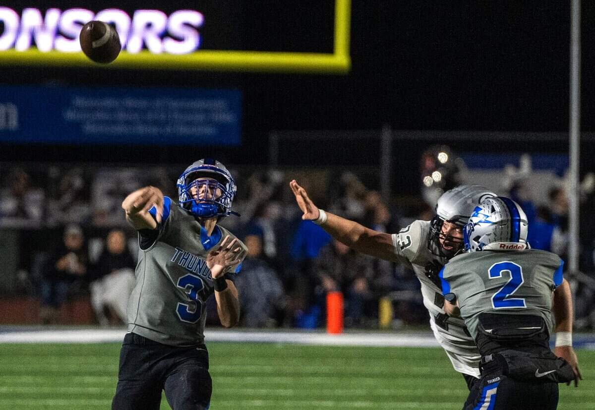 Rocklin Thunder quarterback Reeve Slone (3) throws a touchdown to tight end Keane Frank as the Granite Bay Grizzlies’ Austin Valdez (73) applies pressure last month. The Thunder are the top seed in the Division II playoffs.