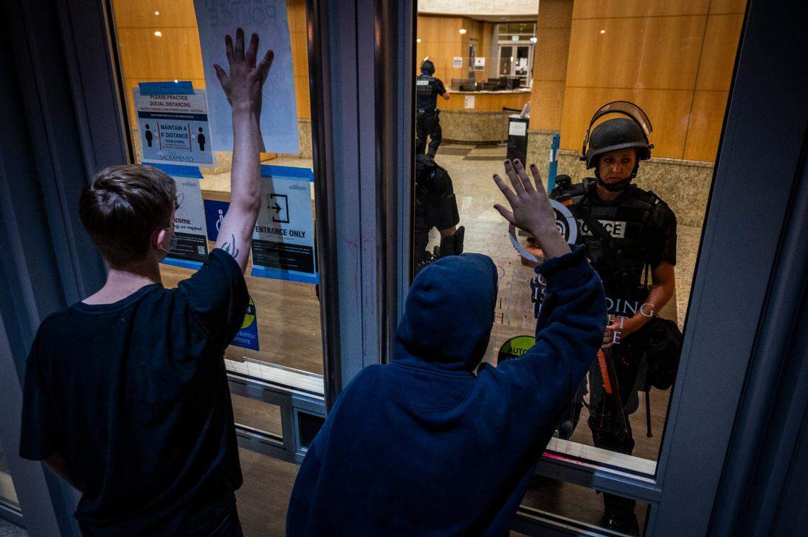 Protesters confront police officers at city hall behind glass in downtown Sacramento on Thursday, Aug. 27, 2020. The Solidarity With Kenosha event  the second demonstration of the evening over the police shooting of Jacob Blake in Wisconsin  started at Cesar E. Chavez Plaza before heading to City Hall.