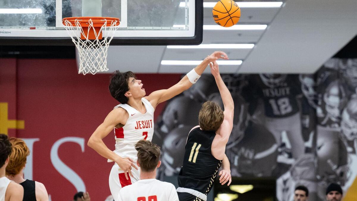 Jesuit Marauder guard/forward Andrej Stojakovic (2) blocks a shot by Rio Americano Raider guard Luke Mason (11) during the third quarter of the high school boys basketball game Friday, Dec. 16, 2022, at Jesuit High School in Carmichael.