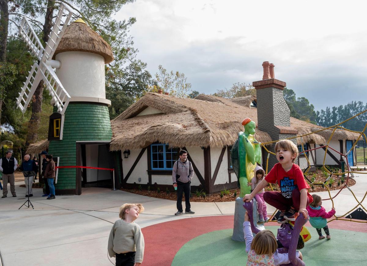 Children including Edward Foster, 4, right, of North Natomas, play outside of the new Story Center, designed as an enchanted thatched cottage, at Fairytale Town in Land Park during the grand opening ribbon cutting event Saturday, Nov. 12, 2022