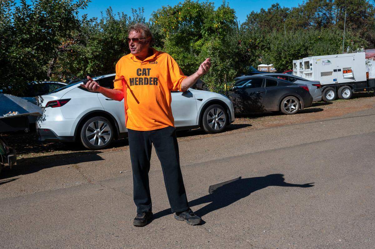 Jerry Visman, the owner of High Hill Ranch, wears a shirt that says “cat herder” while directing traffic as people visit the ranch Saturday at Apple Hill.