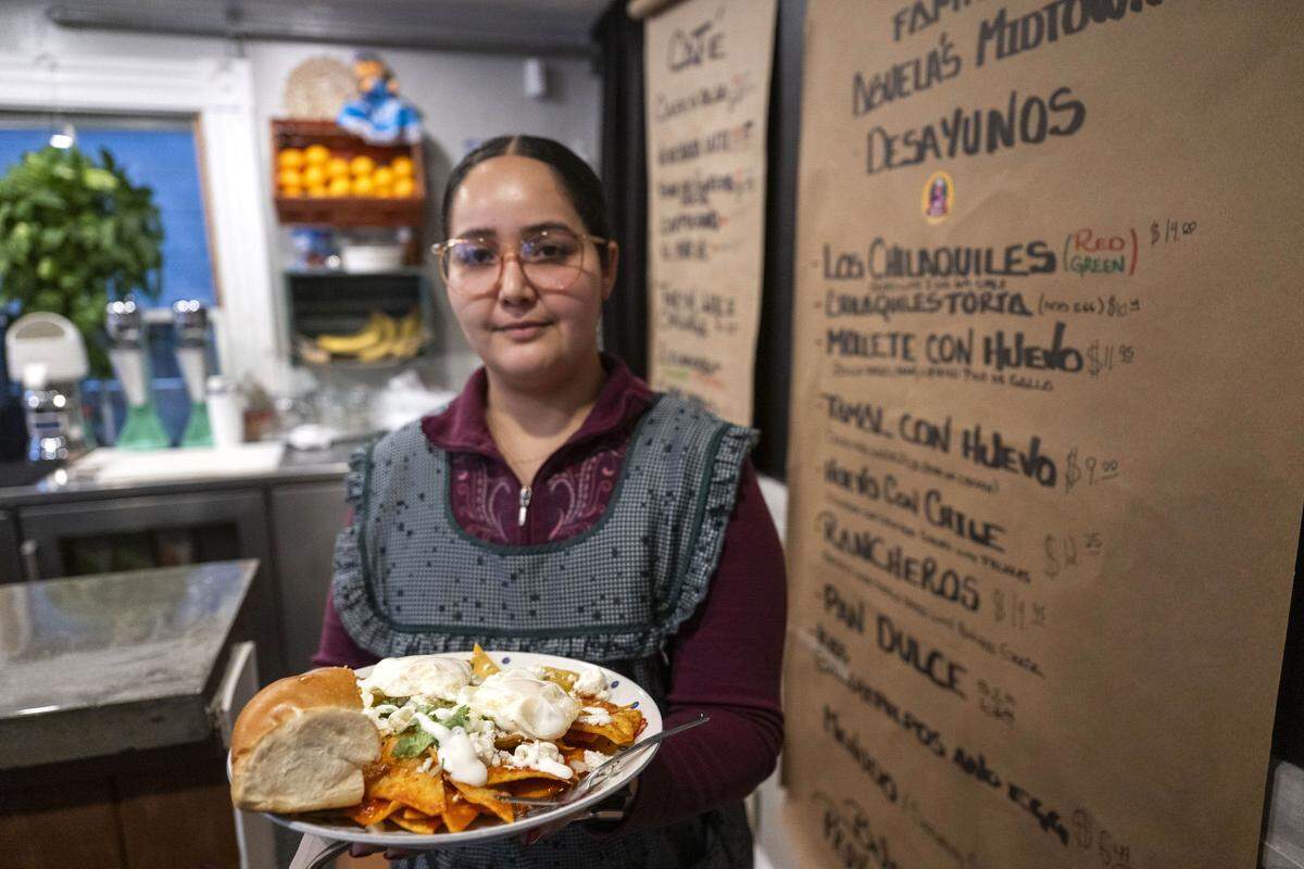 Maria José Sanchez holds a plate of chilaquiles at Abuela’s Midtown restaurant on Friday. The restaurant offers a variety of breakfast items inspired by the grandmothers of staff members.