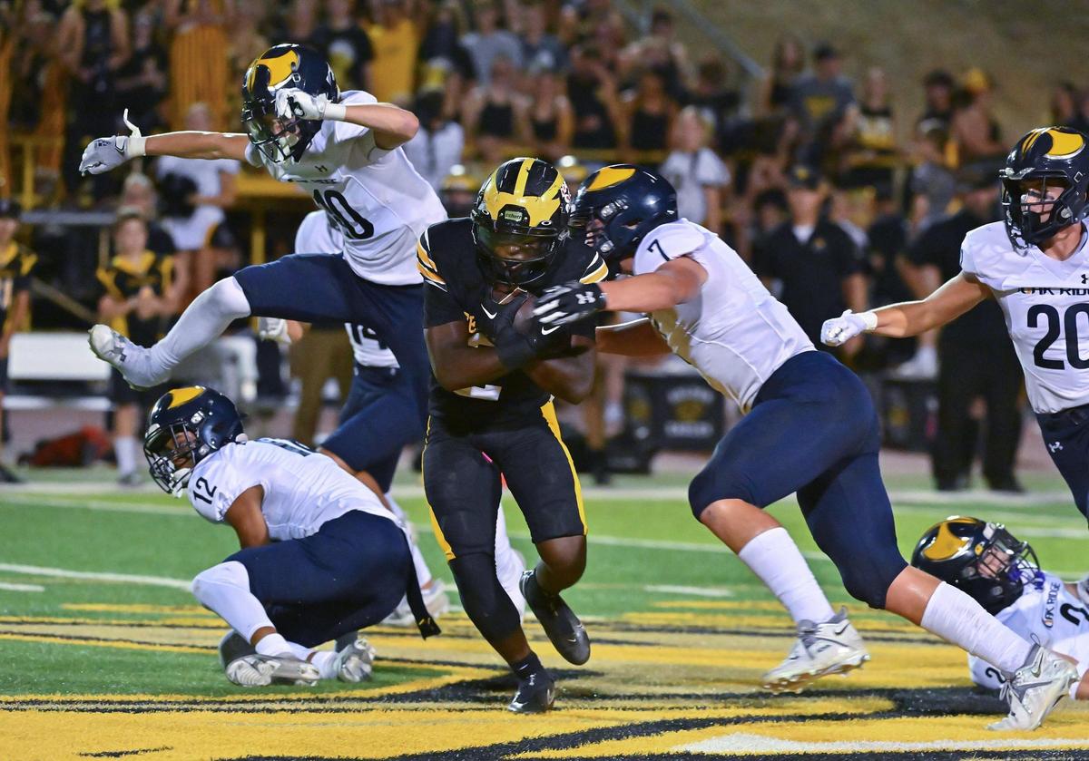 The Del Oro Golden Eagles’ Marcel Urquhart (2) runs the ball up the middle before being tackled by the Oak Ridge Trojans’ Gavin Molloy (7) in the first half of the game on Friday, Oct. 6, 2023, at Del Oro High School in Loomis.