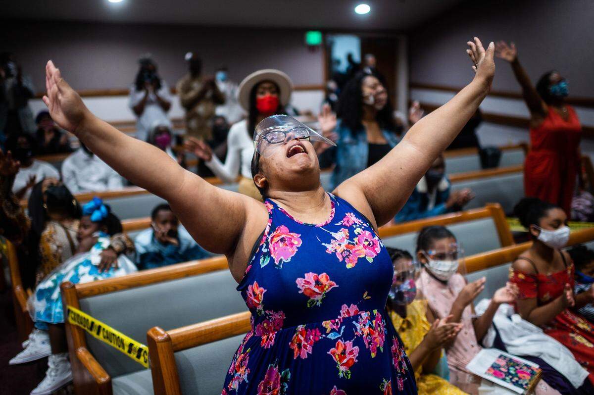 Victoria “Nicole” Samuels of Sacramento, raises her hands in praise during a service at St. Paul Missionary Baptist Church in Oak Park for Easter Sunday services in 2021. It was the first day of indoor services at the church since the beginning of the coronavirus pandemic.
