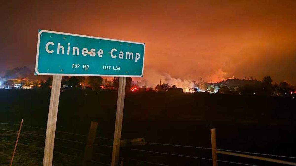 Flames from the 6-5 Fire are seen burning in the Gold Rush-era town of Chinese Camp on Tuesday, Sept. 2, 2025. The blaze is one of a several burning in the TCU September Lightning Complex in Tuolumne and Calaveras counties.