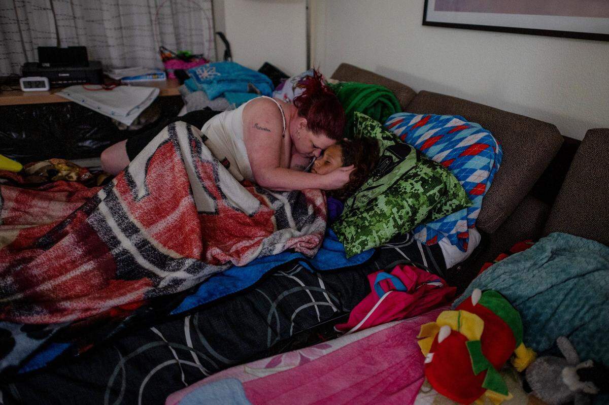 Kristi Phillips comforts her son Tryree Franklin, 11, who wasn’t feeling well, on a sofa bed inside a Sacramento Residence Inn where they stayed in May 2021. Phillips has been on the housing voucher waiting list for more than 12 years.