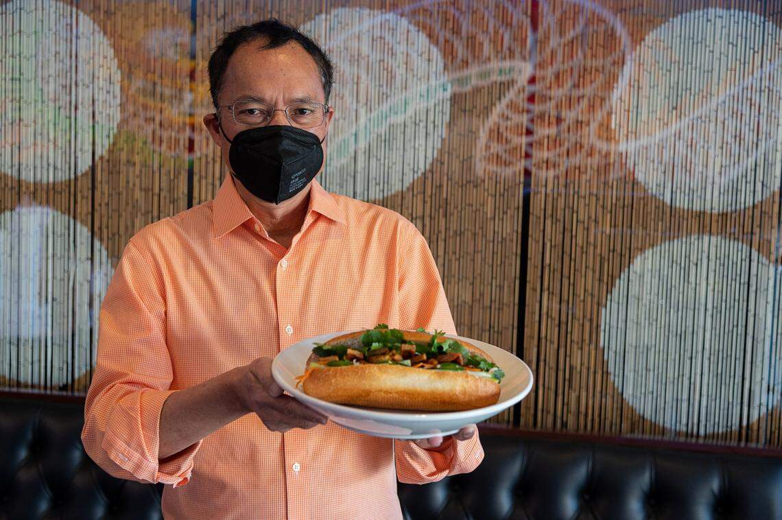 Owner Huan Pham holds a chicken banh mi, the second most popular item next to their pho, at Phở Bác Hoa Viet on Stockton Boulevard.
