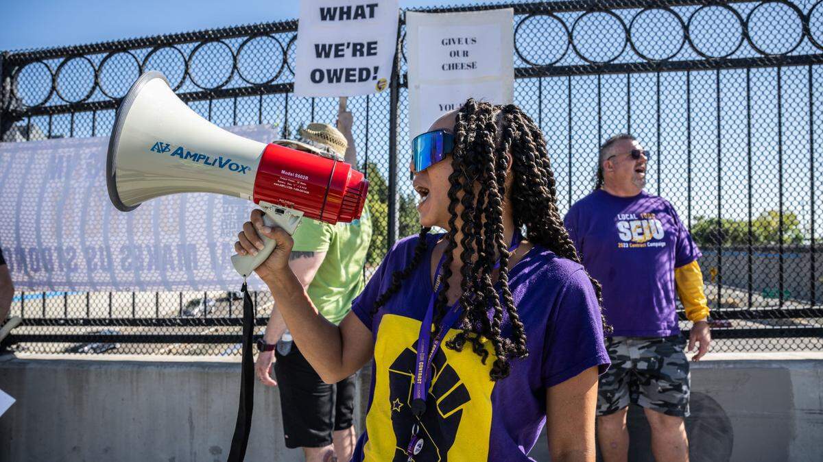 Krystal Coles, an SEIU Local 1000 member, rallies on the O Street bridge over Interstate 5 in downtown Sacramento in August along with members of the California Association of Professional Scientists. Membership at California state worker unions dipped slightly in October 2023 compared to October 2022, recent data show.