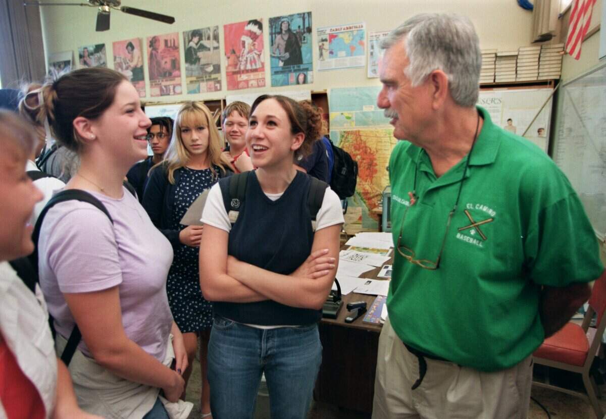 Retiring El Camino High School teacher and baseball coach Frank Calcagno, right, visits with students Stephanie Ambrose, 16, left, and Heather Huetter, 16, center, at the end of their history class in 1998. Calcagno was retiring after 35 years of coaching.