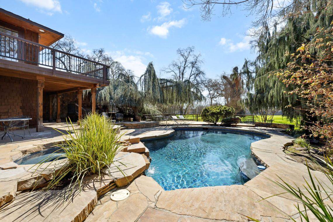 The primary bedroom overlooks the pool and spa with a bathhouse.
