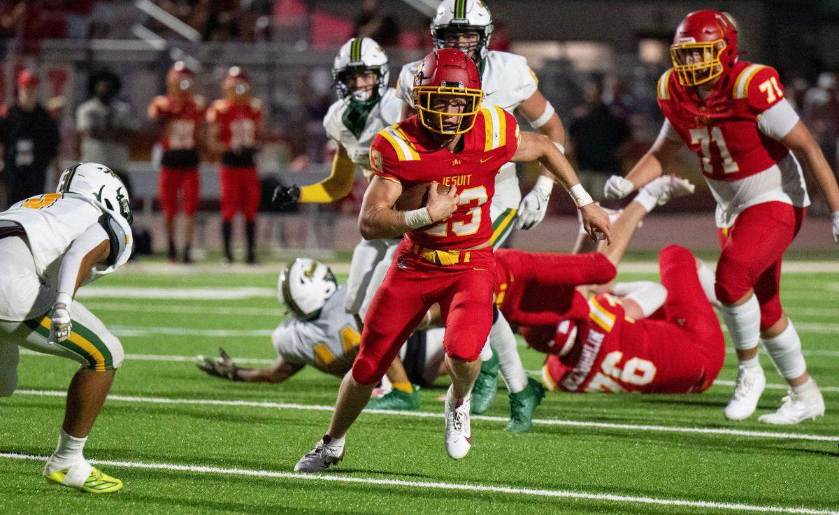 The Jesuit Marauders’ Jack Patock (23) rushes for a first down against the Rio Americano Raiders on Friday at Jesuit High School in Carmichael.