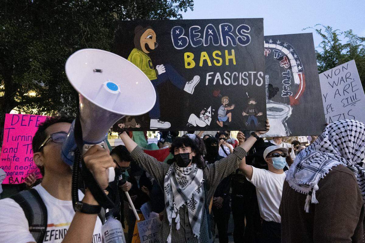 "Bears bash fascists," reads a protester's sign near the line to enter a Turning Point USA tour event at UC Berkeley on Monday, Nov. 10, 2025. 