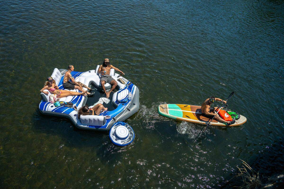 Visitors enjoy a variety of water sports on the American River in the Sunrise Recreation Area on Memorial Day in Rancho Cordova. Cooler, windy weather brought out fewer families to the river.