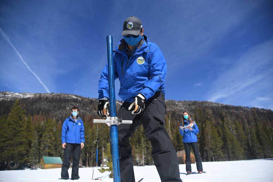 Sean de Guzman, center, snow survey manager with the California Department of Water Resources, measures the snowpack Tuesday, March 1, 2022, at Phillips Station, Calif., near Echo Summit. DWR officials said Californiaâs drought will continue amid below-average snowpack and reservoir levels.