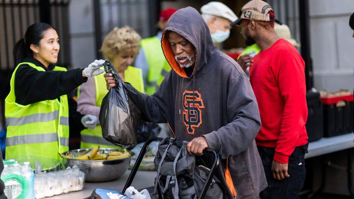Terrence Wilburn receives a bag of food from Angelica De LA Cruz, a volunteer with the Brown Bag Lunch program at the Cathedral of the Blessed Sacrament, in downtown Sacramento on Thursday.