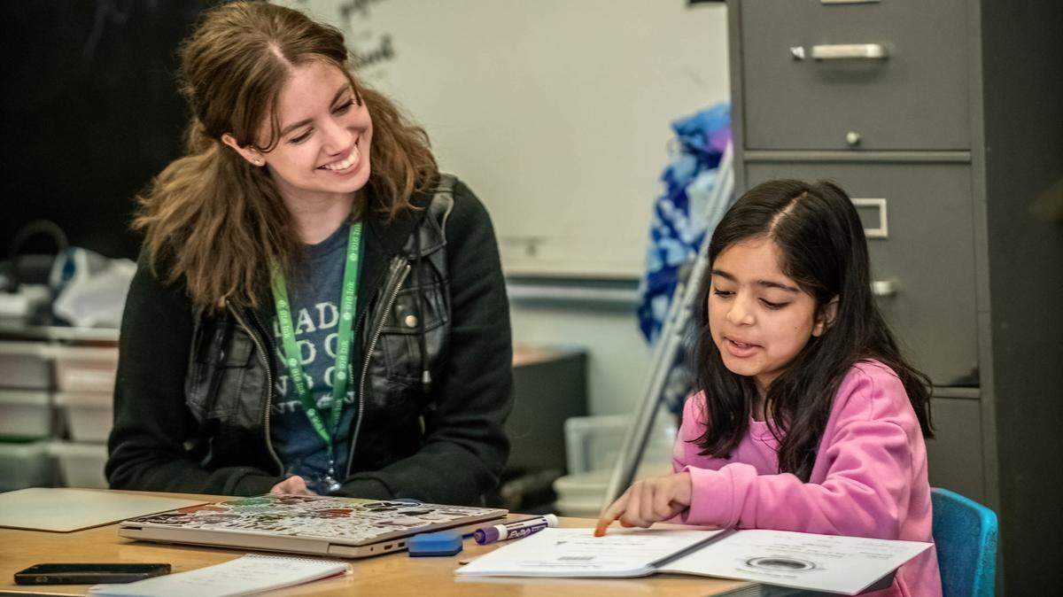 Jessica Seibold with Read On, a literacy tutoring program of 916 Ink, works with a student at F.C. Joyce Elementary School in 2023. 