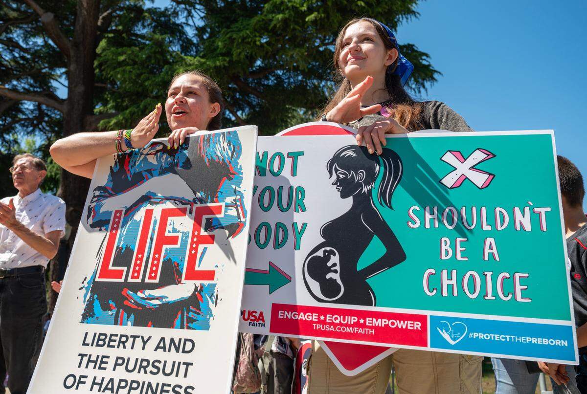 Sisters Isabella Carreiro, 24, left, and Raquel Carreiro, 21, of Harvest Valley Church in Pleasanton, cheer a speaker during the California March for Life rally at the state Capitol on Monday.