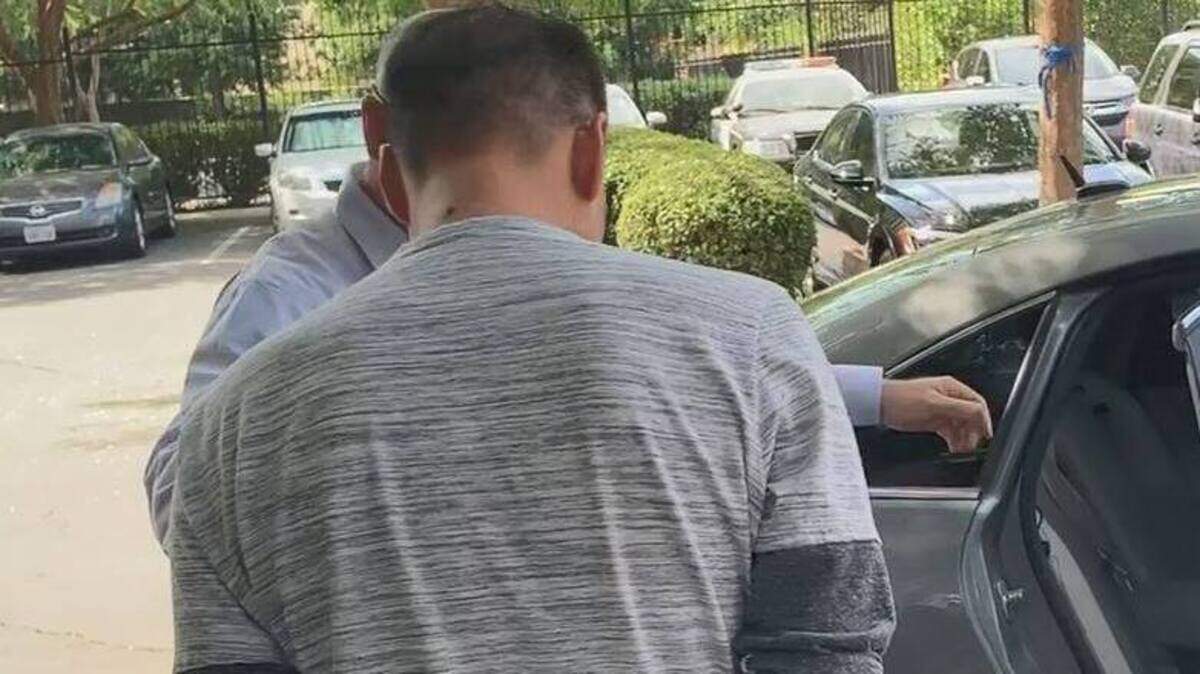 Police escort Andy Hon Vo Chong into a car after he was arrested July 25.