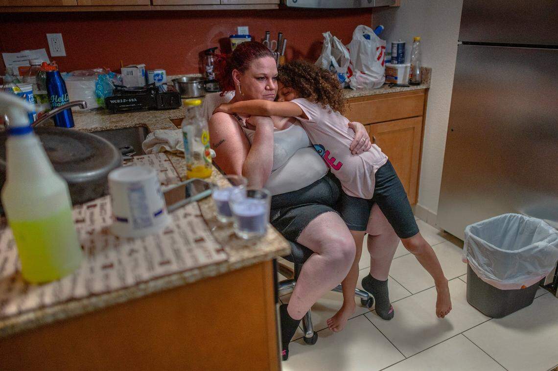 Kristi Phillips, 47, takes a break with daughter Shyann Slain, 7, while cleaning her kitchenette inside the Residence Inn by Marriott where she has been living with her family on Friday May 28, 2021 in Sacramento. “I have anxiety really bad and its starting to make my anxiety worse for me and I’m on the verge of nervous breakdown but I can’t let the kids see that,” Phillips said as her eyes filled with tears over their housing situation. Phillips says she works six days and only takes off on Sunday to provide for her family of five.
