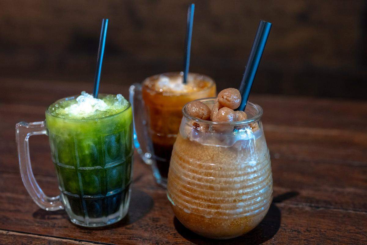 Thai green tea, Thai iced tea and a longan fruit slushie sit on a table in Kin Thai Street Eatery.
