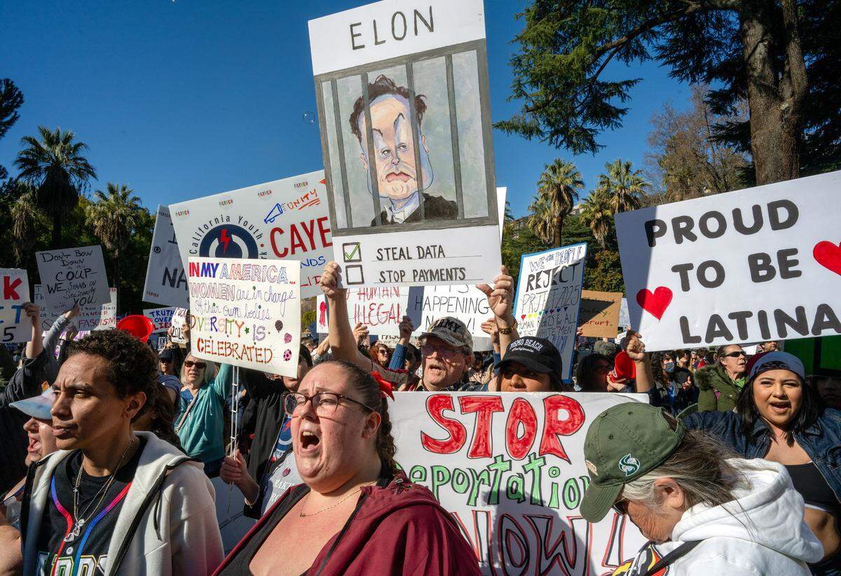 Ashely Gurich, center, of Oakland joins hundreds of demonstrators at a protest against President Donald Trump and his adviser Elon Musk at the California Capitol on Wednesday.