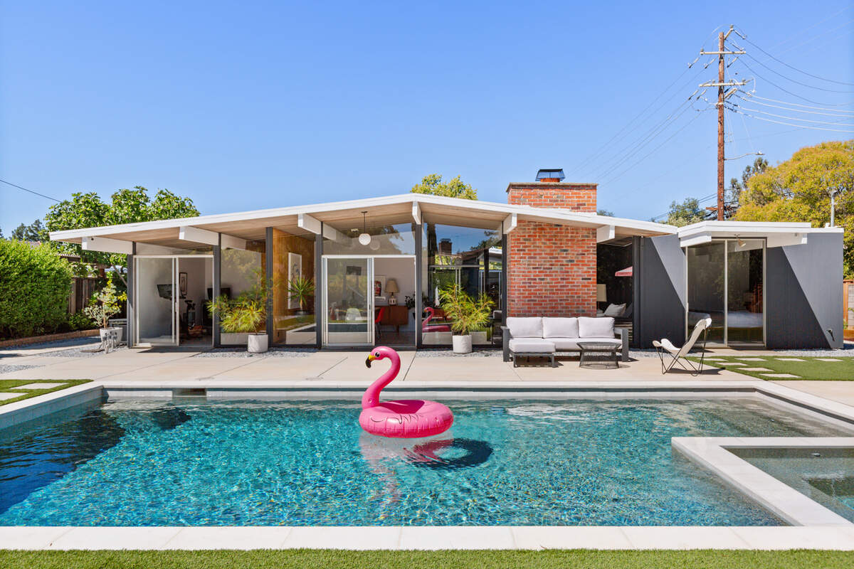 A resort-style backyard with saltwater pool, spa, and heated pergola creates the perfect setting for year-round indoor/outdoor living.