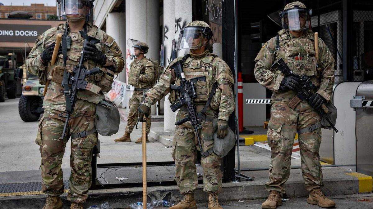 California National Guard personnel stands guard as protesters clash with law enforcement in downtown Los Angeles at the Metropolitan Detention Center on June 8 in Los Angeles.