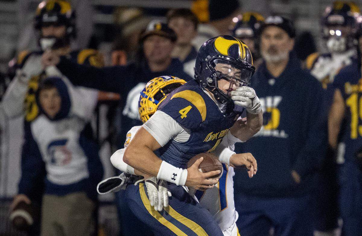 The Oak Ridge Trojans' Luke Taber (4) is tackled by the Grant Pacers' Sosaia Noa (4) in the first half in the CIF Sac-Joaquin Section Division l semifinal football playoff game in El Dorado Hills on Friday, Nov. 21, 2025.
