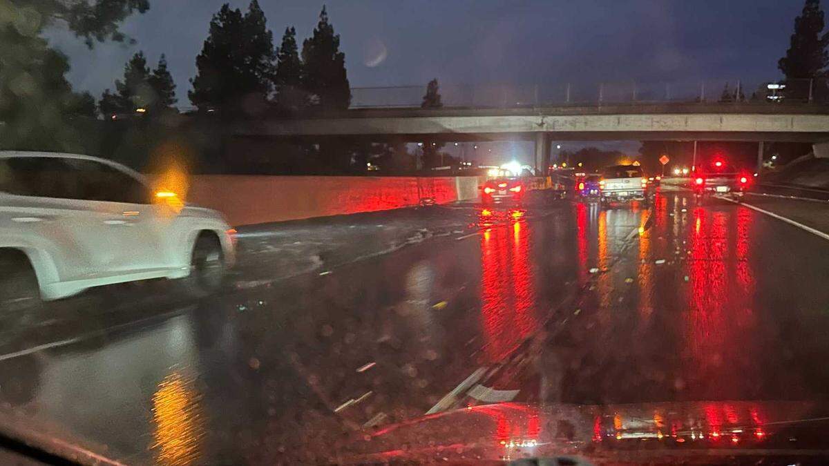 Several vehicles are seen driving through water in a ponded portion of the Capital City Freeway at Exposition Boulevard around 7 a.m. on Wednesday, Dec. 24, 2025. Most capital region freeways had seen slick roads or minor flooding before the morning commute.