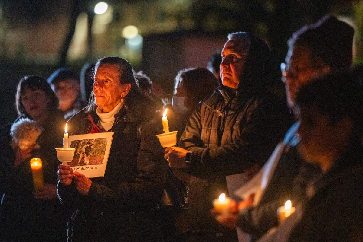 A woman holds a photograph of Alex Pretti, the ICU nurse slain by federal agents in Minneapolis days ago, during a candlelight vigil at Southside Park in Sacramento on Monday.