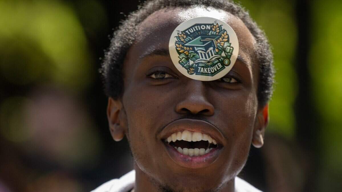 Una calcomanía de ‘Tuition Takeover’ oculta parte de la cara del estudiante Tyrone Humphrey durante una protesta en Sacramento State el miércoles en relación con el alza del 34% de las colegiaturas del sistema de la Universidad Estatal de California.