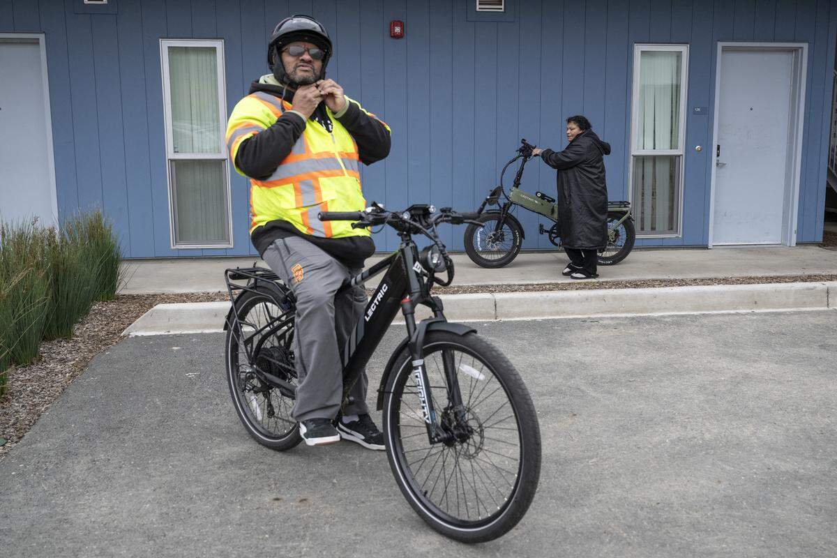 Dewayne McDaniel, 53, and Anna Crespo, 55, right, prepare to ride their e-bikes in  Sacramento on Thursday. McDaniel and Crespo were both beneficiaries of a program supplying vouchers for e-bikes.