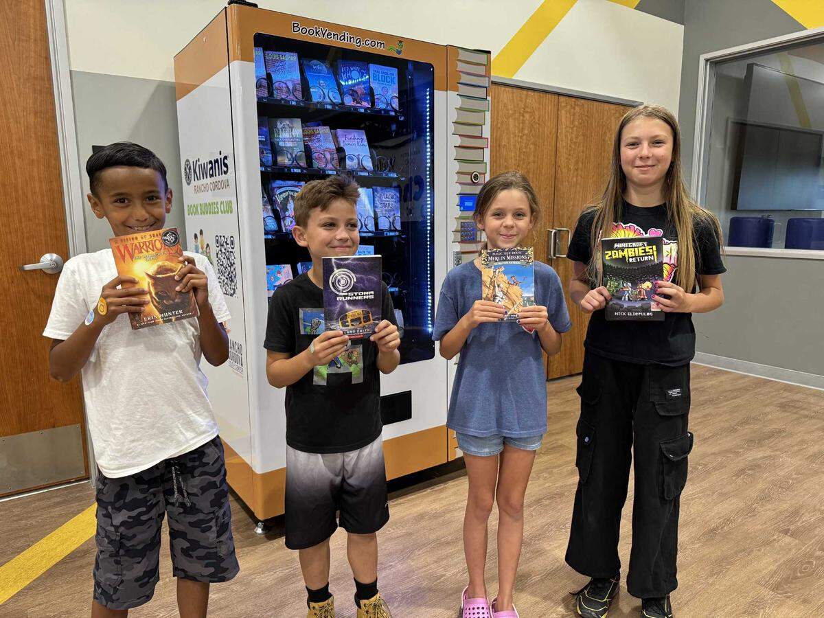 From left, Peyton Vaughn, 7; James Huston, 9; Amelia Vollchansky, 9; and Hazel Huston, 11, pose with books they selected from the book vending machine at the Rancho Cordova Youth Center.