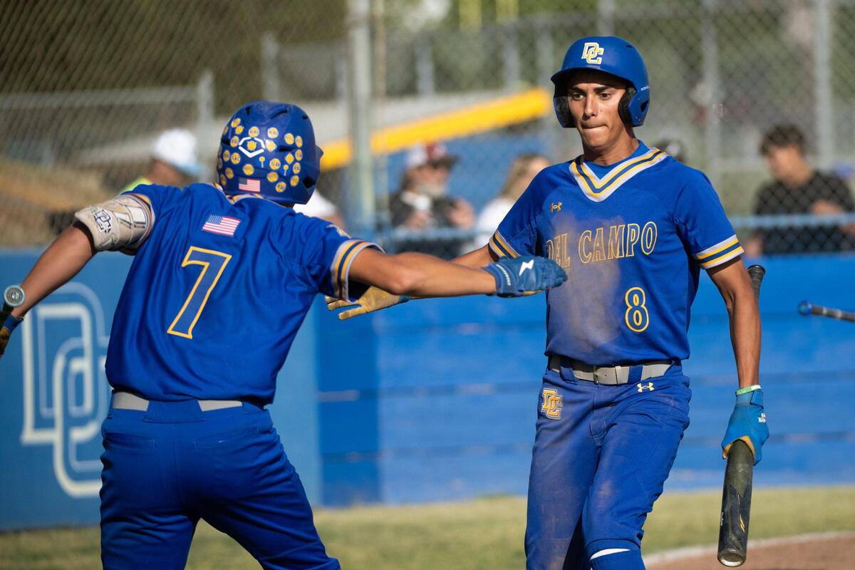 Del Campo Cougars player Angel Reyna (8) is congratulated by Skyler Maynor (7) after scoring the go-ahead run in the fifth inning against the Center Cougars in a first-round Sac-Joaquin Section Division IV baseball playoff game on Wednesday in Fair Oaks.