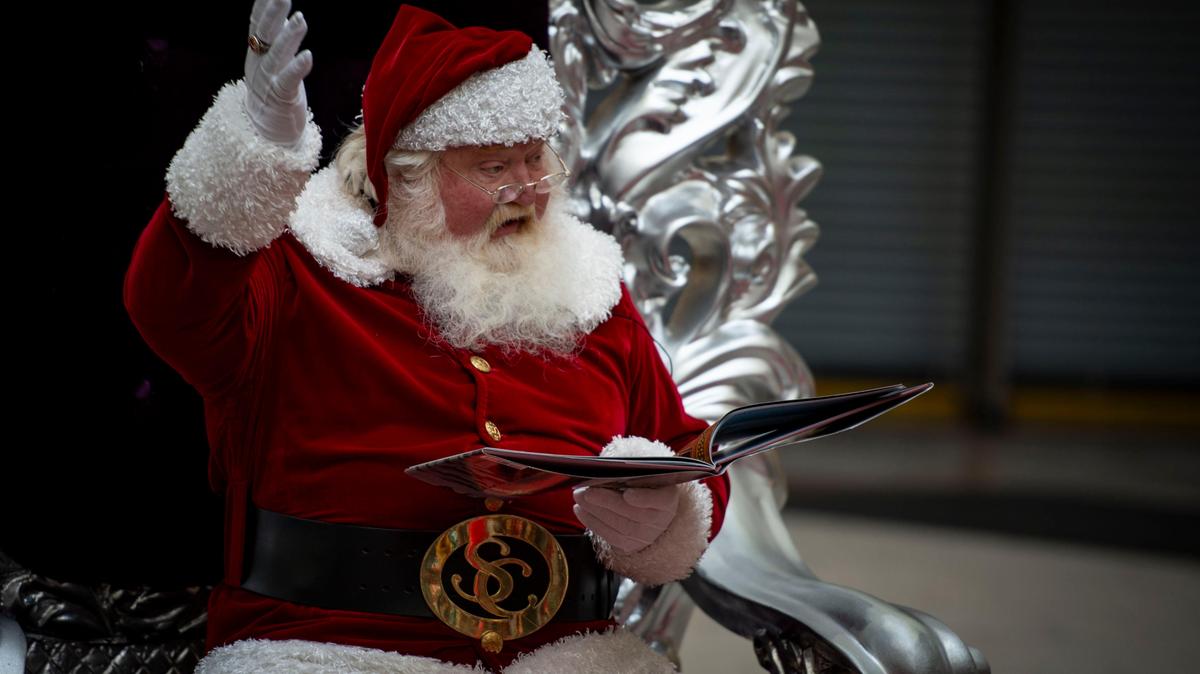 A man dressed as Santa Claus reads The Polar Express at the Arden Fair mall in 2019. 