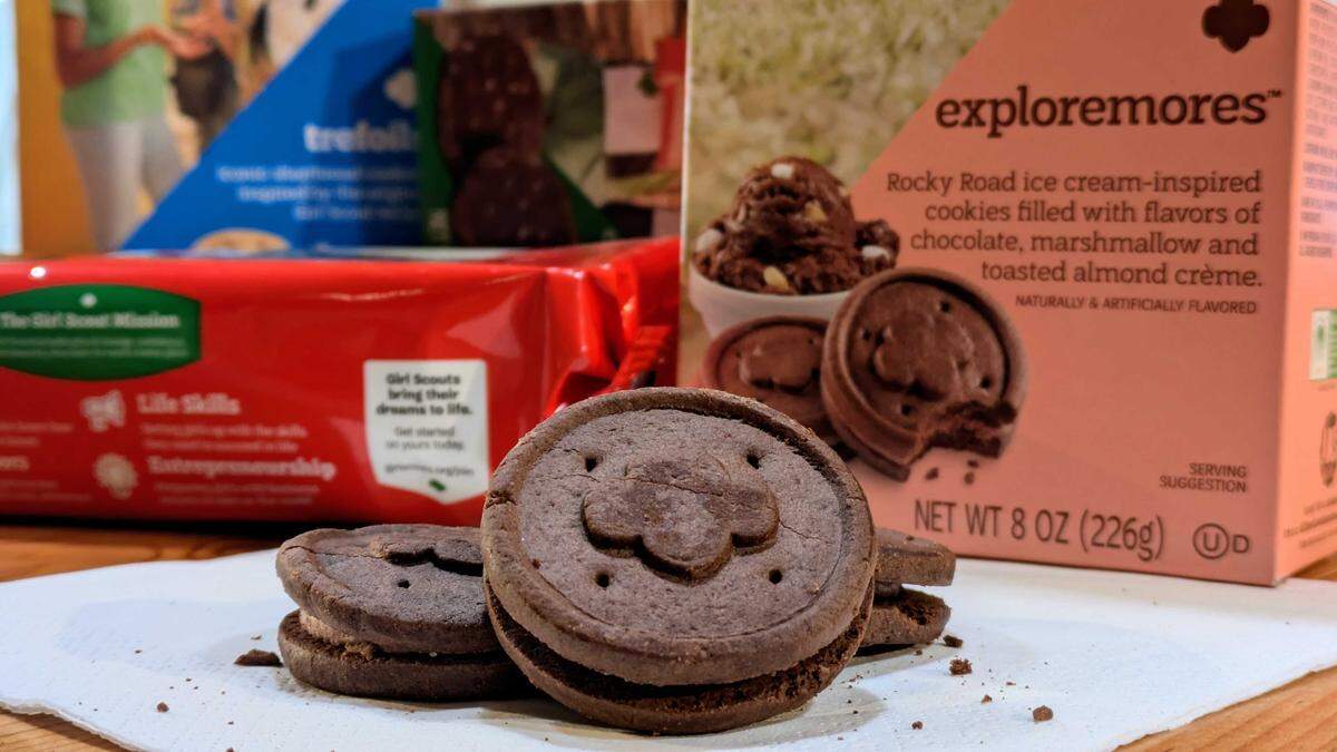 The new 2026 Girl Scout cookies are Exploremores — a sandwich cookie inspired by rocky road ice cream. The cookie is two chocolate wafers filled with marshmallow and toasted almond-flavored cream.