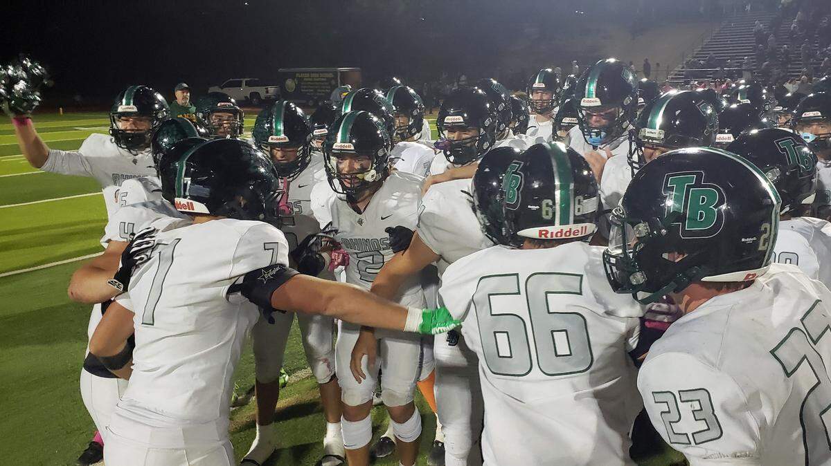 Lincoln’s Twelve Bridges Raging Rhinos players pump up each other before racing to a 51-34 win over Placer High School in Auburn Friday, Oct. 18, 2024, and remain unbeaten at 8-0.